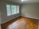 A bedroom with hardwood floors, fresh paint, and a large window at 5703 Kimberly Ln, Norcross, GA 30071