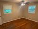 A bedroom with hardwood floors, fresh paint, ceiling fan, and a large window at 5703 Kimberly Ln, Norcross, GA 30071