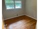 A bedroom with hardwood floors, fresh paint, and a large window at 5703 Kimberly Ln, Norcross, GA 30071