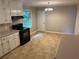 Functional kitchen with white cabinetry, black appliances, and neutral flooring at 5703 Kimberly Ln, Norcross, GA 30071