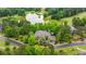 Beautiful stone house with a brick driveway surrounded by trees, landscaping, golf course and a pond in the backyard at 939 Middle Fork Trl, Suwanee, GA 30024