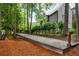 Backyard bocce ball court adjacent to a stone home nestled amongst mature trees, offering fun outdoor activities at 939 Middle Fork Trl, Suwanee, GA 30024