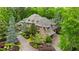 Stunning stone home with lush landscaping, a brick driveway, and a three-car garage surrounded by mature trees at 939 Middle Fork Trl, Suwanee, GA 30024