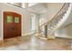Grand foyer with travertine flooring, a curved staircase, and wood doors with leaded glass inserts at 939 Middle Fork Trl, Suwanee, GA 30024
