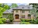 Elegant brick home featuring a stone archway, a wooden double door entry, and a perfectly manicured landscape at 939 Middle Fork Trl, Suwanee, GA 30024