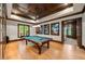 Elegant game room featuring a pool table, coffered ceilings, wood floors and a display case with collectible items at 939 Middle Fork Trl, Suwanee, GA 30024
