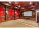 Cozy home theater with plush red accents, a large projection screen, and ambient lighting for a cinematic experience at 939 Middle Fork Trl, Suwanee, GA 30024