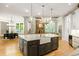 Gourmet kitchen with a large island, stone fireplace, modern appliances, and hardwood floors at 939 Middle Fork Trl, Suwanee, GA 30024