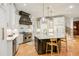 Gourmet kitchen with white cabinets, a large island, stainless steel appliances, and a custom range hood at 939 Middle Fork Trl, Suwanee, GA 30024