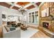 Spacious living room featuring a stone fireplace, coffered ceiling, hardwood floors, and large windows at 939 Middle Fork Trl, Suwanee, GA 30024