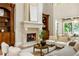 Bright living room with a fireplace, built-in bookcases, and an open floor plan with views of the backyard at 939 Middle Fork Trl, Suwanee, GA 30024