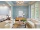 Stylish sitting room with a chandelier, hardwood floors, comfortable seating, and natural light at 939 Middle Fork Trl, Suwanee, GA 30024