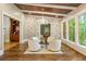 Bright sitting room with a fireplace, hardwood flooring, white brick accent wall, and many windows with natural lighting at 939 Middle Fork Trl, Suwanee, GA 30024