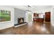 Open-concept living room boasts hardwood floors, fireplace with painted brick surround, and modern light fixture at 1436 Diamond Head Drive Dr, Decatur, GA 30033