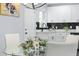 Bright dining area with a view into the modern kitchen with white cabinets and black tile backsplash at 1931 Selwyn Dr, Decatur, GA 30035