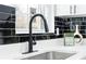 Kitchen faucet with black backsplash, white cabinets, and quartz countertop at 1931 Selwyn Dr, Decatur, GA 30035