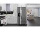 Contemporary kitchen adjacent to living area featuring stainless steel refrigerator and white cabinets at 1931 Selwyn Dr, Decatur, GA 30035