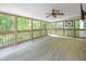 Bright and airy screened porch overlooking lush greenery and a ceiling fan at 240 Rose Ridge Dr, Canton, GA 30115