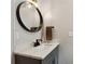 Modern bathroom with granite counters, dark fixtures and a round mirror at 2721 Old Concord Se Rd, Smyrna, GA 30082