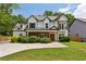 Charming two-story home featuring a stone facade, covered porch, and a manicured lawn at 2721 Old Concord Se Rd, Smyrna, GA 30082