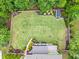 Aerial view of the backyard with lush lawn, established garden beds, mature trees and a storage shed at 7493 Elderberry Dr, Douglasville, GA 30135