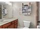 Bathroom with single vanity, mirror, shelving and toilet at 7493 Elderberry Dr, Douglasville, GA 30135