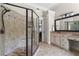 This bathroom features a large glass shower, vanity, neutral walls, and a decorative mirror at 7493 Elderberry Dr, Douglasville, GA 30135