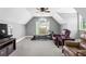This bonus room features neutral walls, plush carpet, a ceiling fan, and a window providing natural light and fresh air at 7493 Elderberry Dr, Douglasville, GA 30135