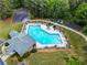 An aerial shot of the community pool and playground with mature trees, lounge chairs and green space at 7493 Elderberry Dr, Douglasville, GA 30135