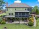 Rear exterior view of house featuring a multi-level deck, screened porch, and professionally landscaped yard at 7493 Elderberry Dr, Douglasville, GA 30135