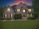 Charming brick home with a well-manicured lawn and mature landscaping at twilight at 7493 Elderberry Dr, Douglasville, GA 30135