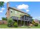 Back exterior view of a two-story home with a deck, screened-in porch, and landscaped backyard at 7493 Elderberry Dr, Douglasville, GA 30135