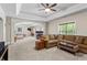 Spacious living room featuring a ceiling fan, plush carpet, and an arched entryway to another room at 7493 Elderberry Dr, Douglasville, GA 30135