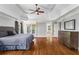Serene main bedroom featuring hardwood floors, a tray ceiling, and an ensuite bathroom at 7493 Elderberry Dr, Douglasville, GA 30135