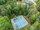 Aerial view showcasing the community tennis courts surrounded by mature trees and walking trails at 7493 Elderberry Dr, Douglasville, GA 30135