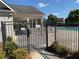 Community pool with a secure black metal fence, entrance gate, and small garden at 8850 Grappe Trace, Suwanee, GA 30024