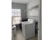 This laundry room features a large window, washer, dryer, and overhead shelving at 8850 Grappe Trace, Suwanee, GA 30024