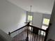 View from staircase of spacious living room featuring fireplace and large windows at 8850 Grappe Trace, Suwanee, GA 30024