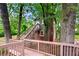Exterior view of a log cabin style house with a wooden deck and stairs nestled among trees at 2828 Cloverhurst Dr, Atlanta, GA 30344