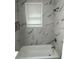 Bathroom featuring tub, white marble-like tile, silver fixtures, and niche at 2346 Pryor Sw Rd, Atlanta, GA 30315