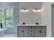 Bright bathroom featuring a dual sink vanity, modern lighting, and a large window overlooking the property at 3599 Centerville Rosebud Rd, Snellville, GA 30039