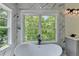 Soaking tub with black faucet and luxury marble wall design at 3599 Centerville Rosebud Rd, Snellville, GA 30039