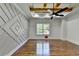 Bedroom boasts wood floors, a decorative wall, modern ceiling fan, and large window at 3599 Centerville Rosebud Rd, Snellville, GA 30039
