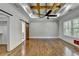 Bedroom boasts wood floors, a decorative wall, modern ceiling fan, and sliding barn doors at 3599 Centerville Rosebud Rd, Snellville, GA 30039