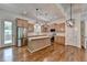 Open kitchen boasts stainless appliances, center island, and hanging pendant lights at 3599 Centerville Rosebud Rd, Snellville, GA 30039