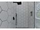 Modern shower with hexagon tiles, black fixtures, and a built-in niche for storage at 3599 Centerville Rosebud Rd, Snellville, GA 30039