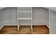 Walk-in closet features open shelving with wood floor at 3599 Centerville Rosebud Rd, Snellville, GA 30039