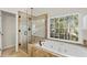 Bright bathroom with a glass shower and a luxurious soaking tub by the window at 3640 Ridgeway Ter, Suwanee, GA 30024