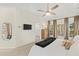 Bright bedroom features a ceiling fan, large windows, and a mounted TV at 3640 Ridgeway Ter, Suwanee, GA 30024