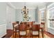 Elegant dining room with a chandelier, hardwood floors, and a large window for natural light at 3640 Ridgeway Ter, Suwanee, GA 30024